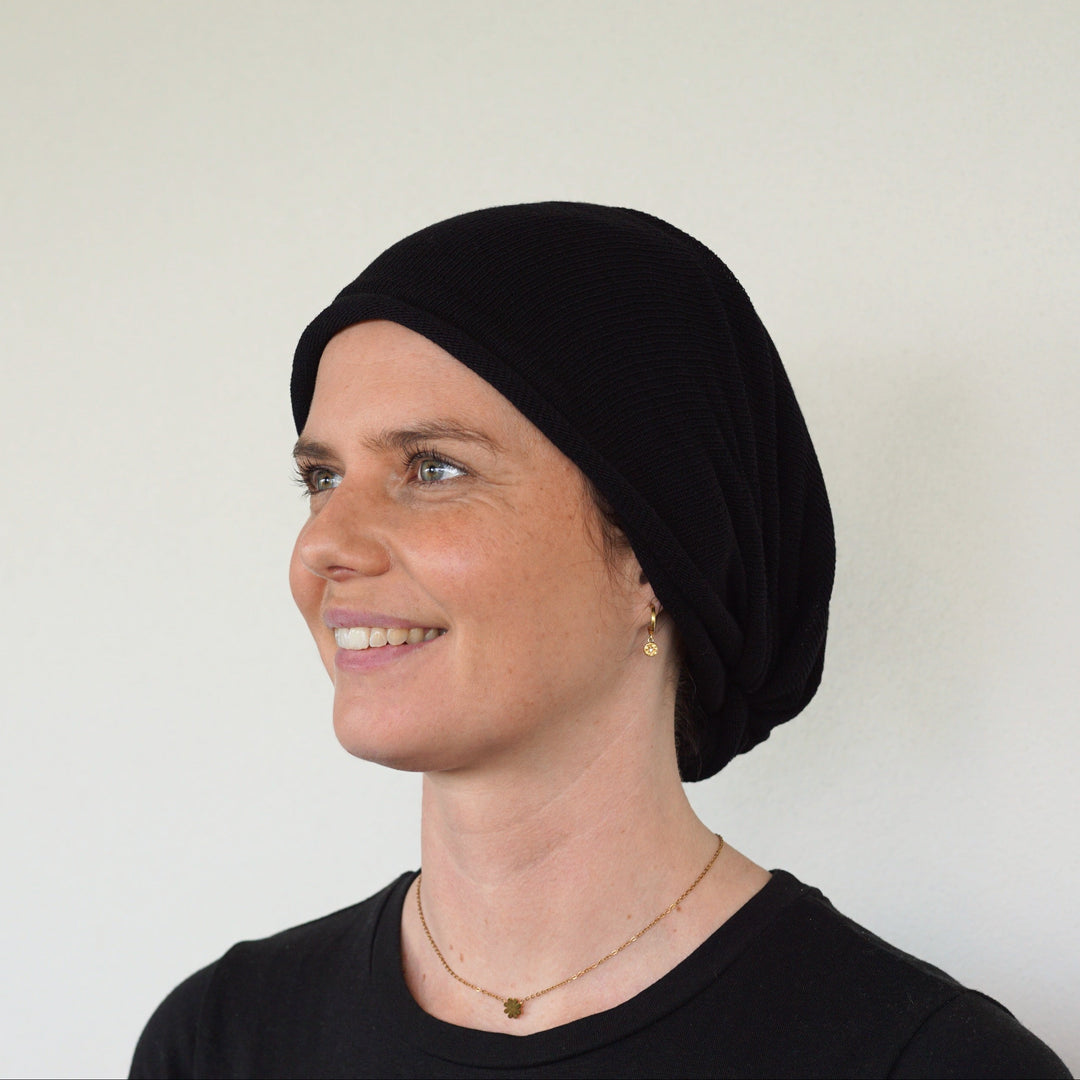 Woman wearing a black headscarf against a white background