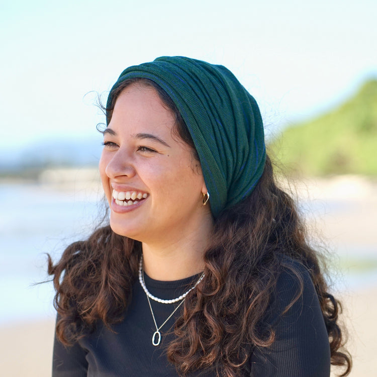 Woman wearing a green headscarf on a beach