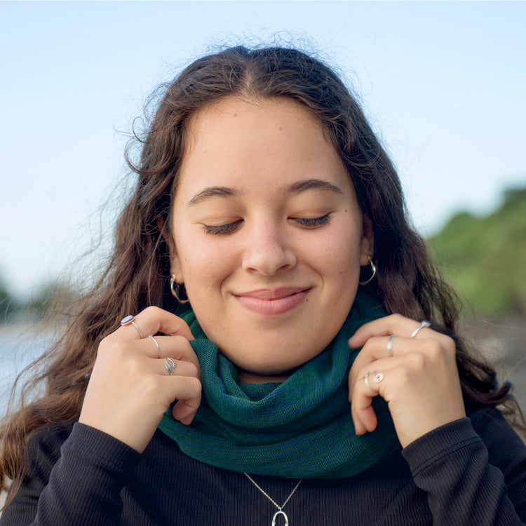 Woman wearing a green scarf with a blurred natural background